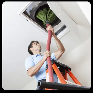 cleaning an air duct with a rotating brush attached to a large red hose