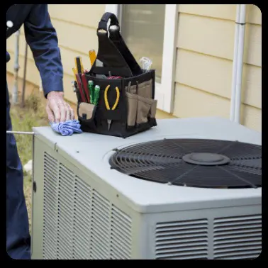 A technician is shown servicing an outdoor AC unit