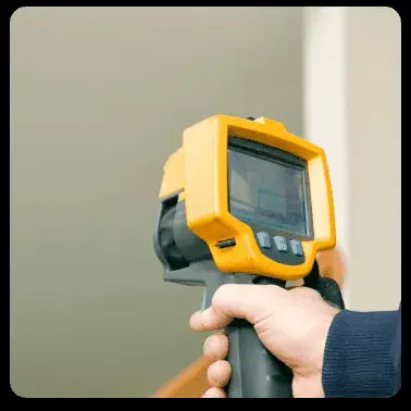 A hand holds a yellow thermal imaging camera