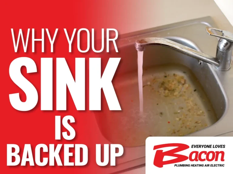 Kitchen sink filled with food scraps and water running from the faucet, with large text reading ‘Why Your Sink Is Backed Up’ and the Bacon Plumbing Heating Air Electric logo.