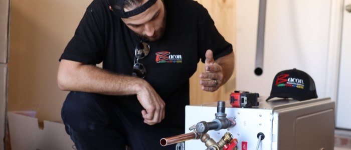 bacon worker repairing a water heater